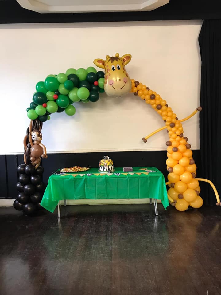 Jungle themed balloon arch with monkey and giraffe